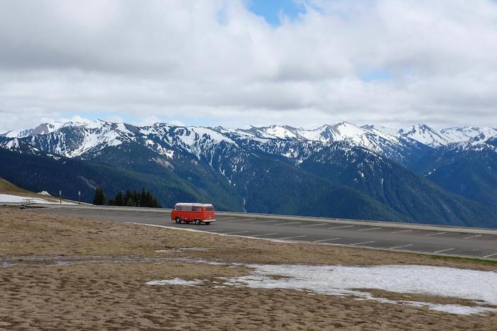 Een rode camper die rijdt door de bergen in olympic national park
